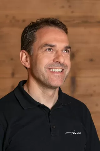 Wüthrich Gottfried mit einem schwarzen Polo Shirt mit Zimmerei Hirschi Logo